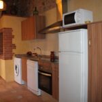 "Cuina rústica amb mobles de fusta i taulell de pedra."